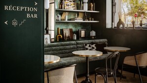 Un área de recepción con bar, asientos y estantes con objetos decorativos.