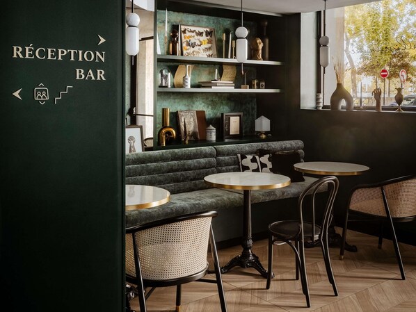 A reception bar area with a green wall, a sofa, and round tables. - Hôtel Mercure Paris Tour Eiffel Pont Mirabeau (Paris)