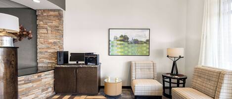A modern living room with a stone accent wall, a flat-screen TV, a fireplace, a sofa, and a coffee table.