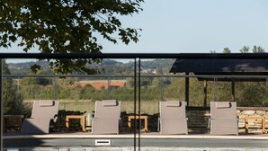 A pool area with lounge chairs and a stone wall.