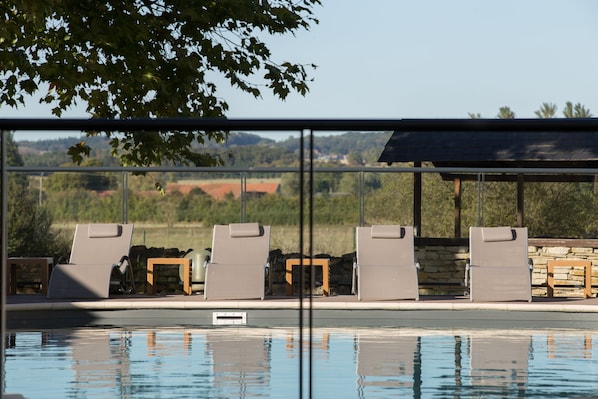 Piscine extérieure en saison, chaises longues