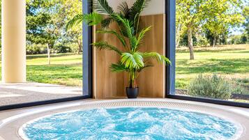 Un jacuzzi con vista a un jardín y árboles.