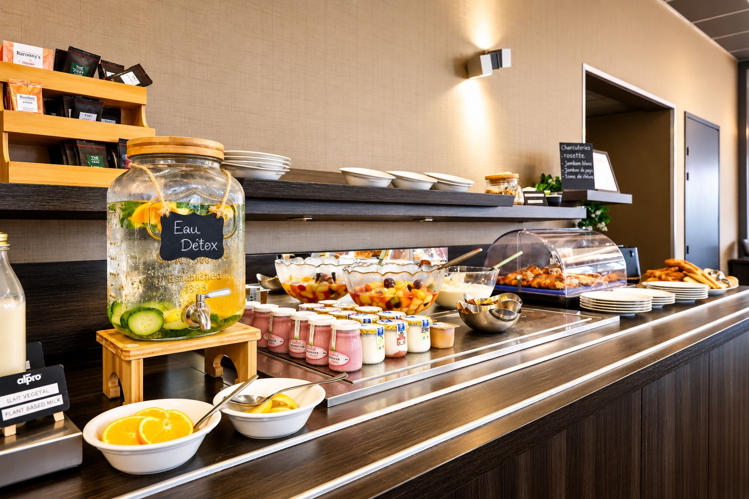 A buffet counter with various food items, a large water dispenser, and a selection of condiments.