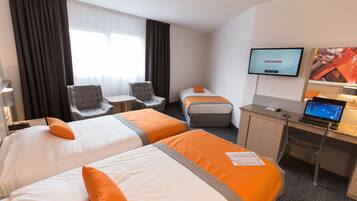 Une chambre d’hôtel avec deux lits, un bureau avec un ordinateur portable, une télévision et une chaise.