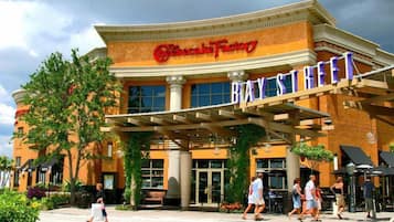 The exterior of the Bayside Hotel with the Cheesecake Factory sign above the entrance.
