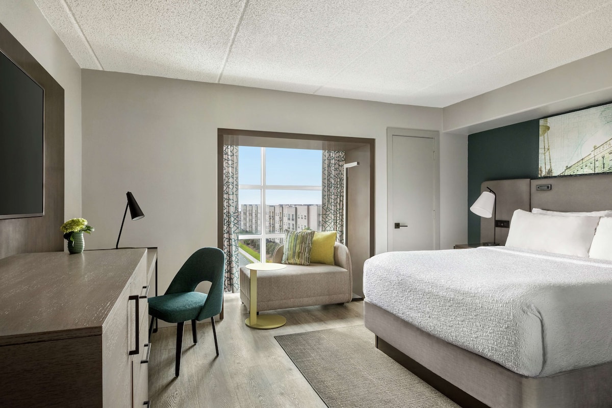 Ett modernt hotellrum med en säng, ett skrivbord och en soffa.