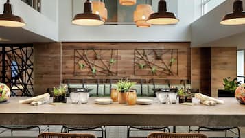 Une cuisine moderne dotée d’un grand îlot central, de luminaires suspendus et d’un revêtement mural en bois orné de motifs géométriques.