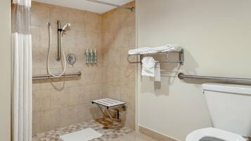 A bathroom with a shower, toilet, and a towel rack.