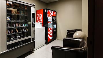 Zona de máquinas expendedoras con una máquina de Coca-Cola y otra de aperitivos.