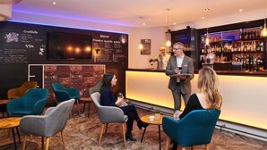 A bar area with seating and a menu board.
