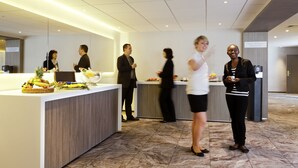 A modern hotel lobby with a reception desk, a buffet area with fruits and beverages, and a spacious layout with marble flooring. - Mercure Rennes Centre Gare (Rennes)