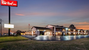 A Red Roof Inn with a large sign, multiple connected buildings, and a well-lit parking area. - Red Roof Inn Vincennes (Vincennes)