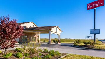 A Red Roof Inn with a covered parking area and a clear sky.