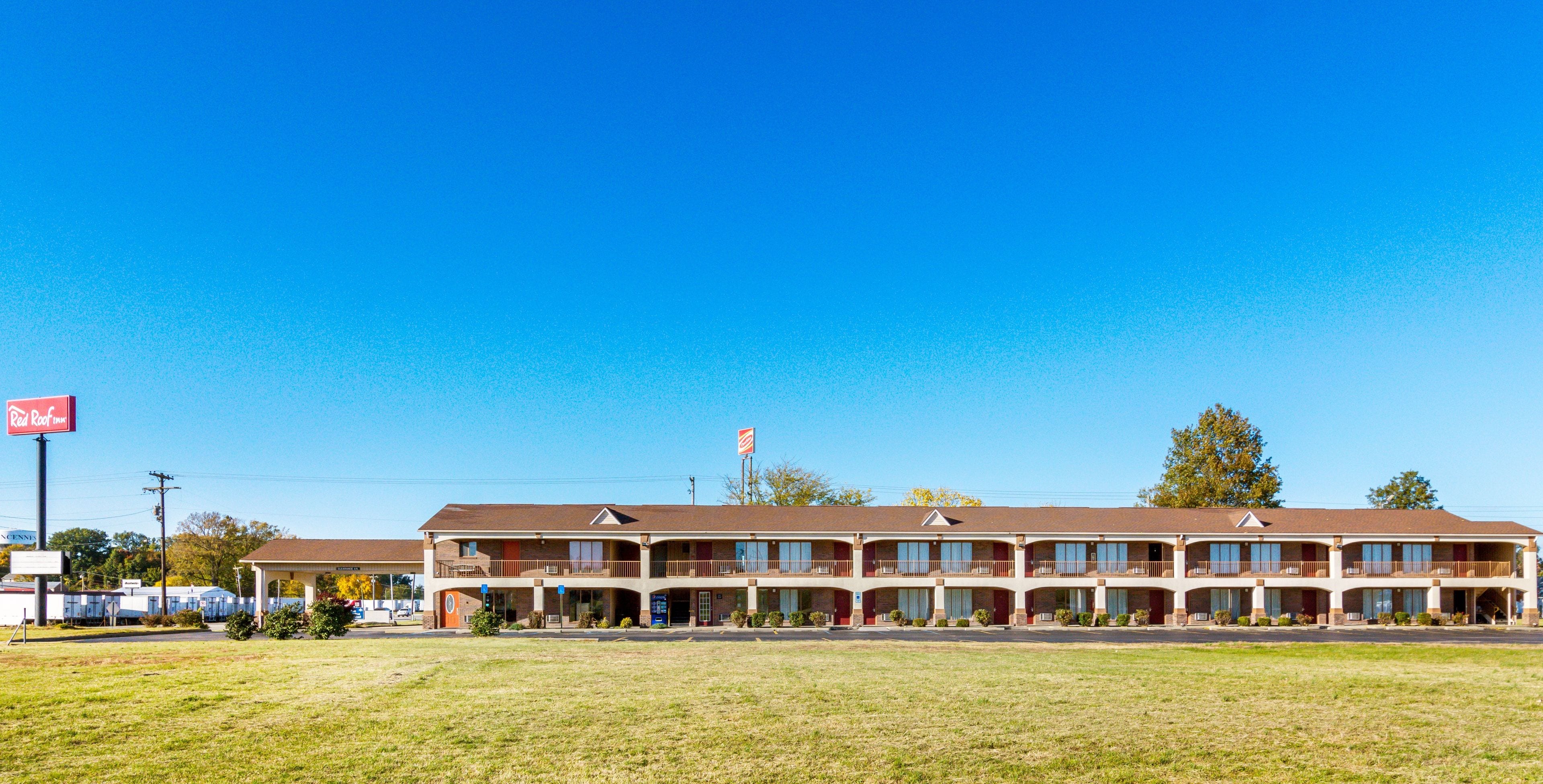 Um motel com estrutura em dois andares, várias varandas e telhado plano.