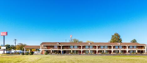 A motel with a two-story structure, multiple balconies, and a flat roof.
