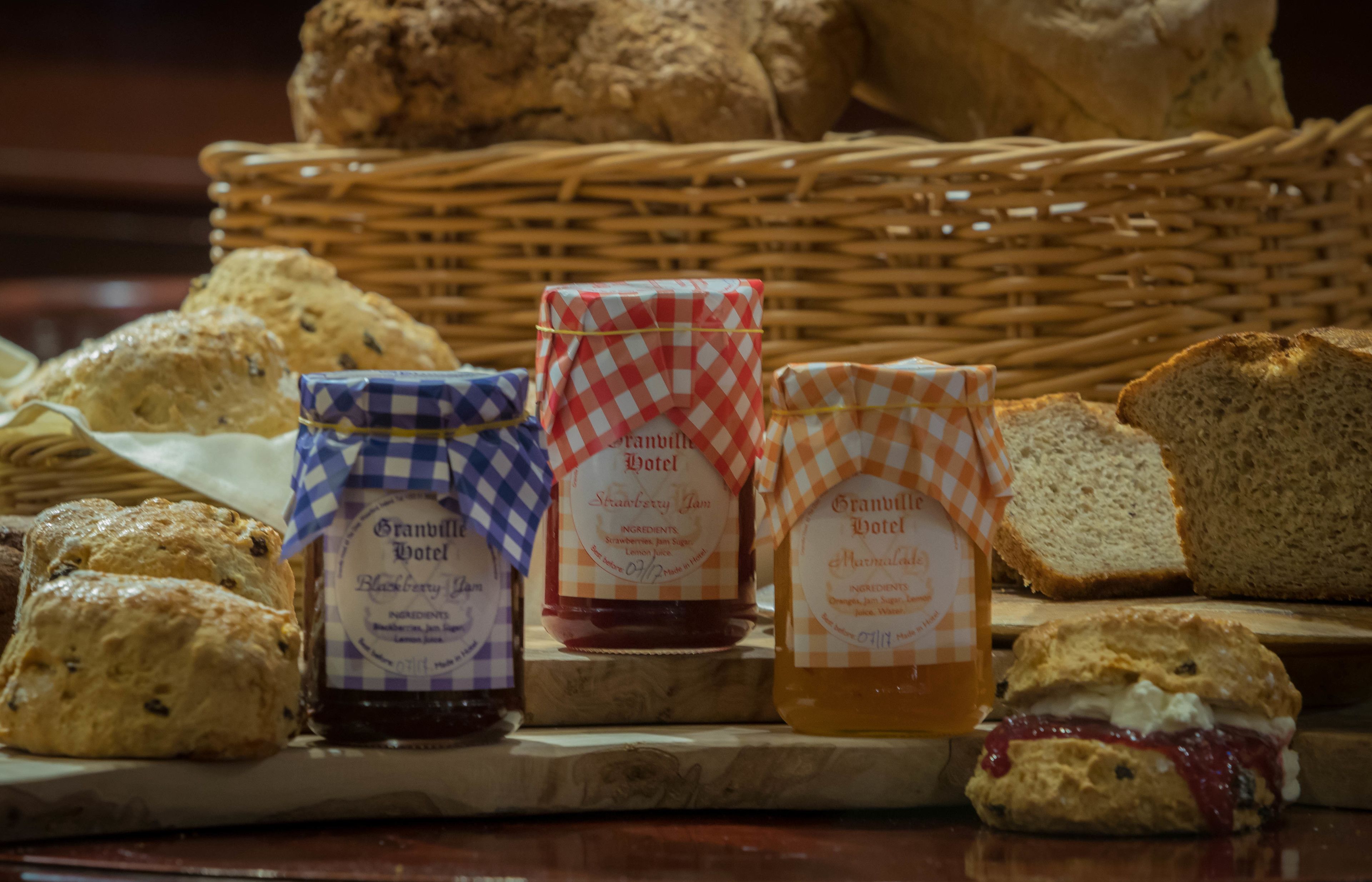 A variety of baked goods including scones, biscuits, and jam jars labeled 'Strawberry Jam' and 'Granville Hotel'.