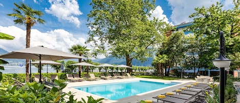 Piscine extérieure, parasols de plage, chaises longues