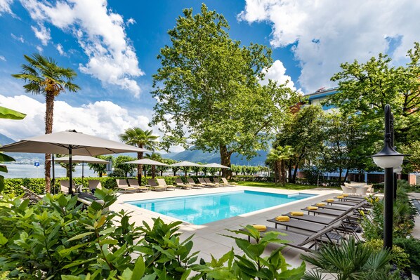 Piscine extérieure, parasols de plage, chaises longues