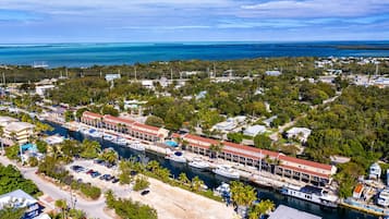 An aerial view of a coastal town with a marina, boats, and a mix of residential and commercial buildings.