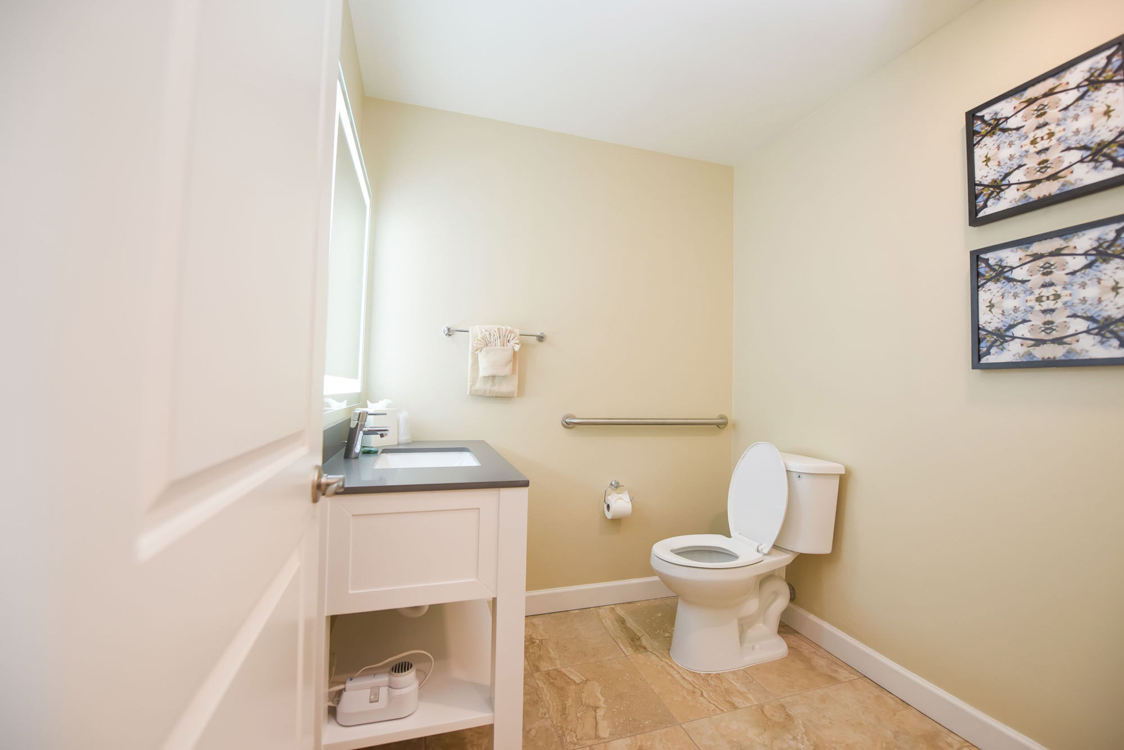 A bathroom with a toilet, sink, and towel rack.