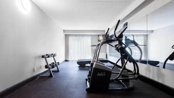 A gym with treadmills, a stationary bike, and dumbbells.