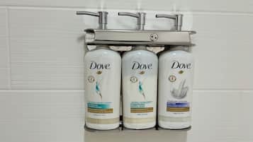 Three Dove shampoo bottles mounted on a wall-mounted holder.
