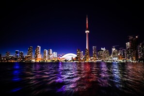 A nighttime city skyline with illuminated buildings and a prominent tower. - Holiday Inn Express Toronto - Downtown by IHG (Toronto)