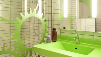 A bathroom with a green sink, white tiles, and a large mirror.