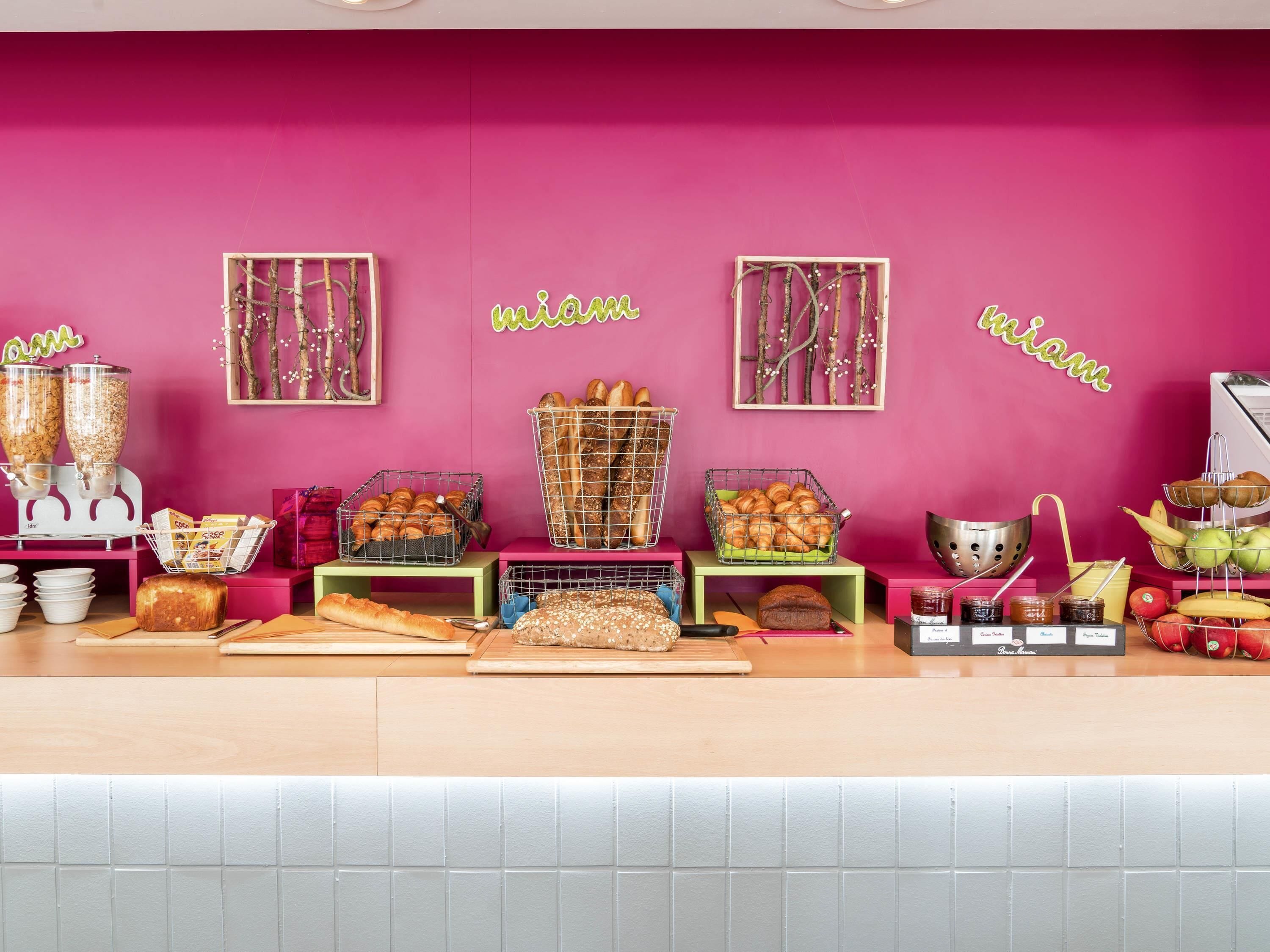 A bakery counter with various baked goods and jars of preserves.