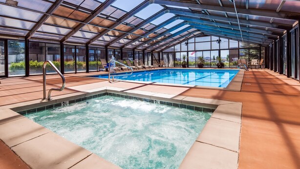 A glass-enclosed indoor pool with a hot tub and lounge area. - Best Western Paradise Inn (Beaver)