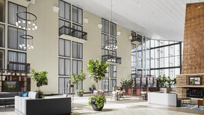 A spacious lobby with a modern design, featuring a large seating area, multiple plants, and a fireplace. - Holiday Inn Asheville Biltmore by IHG (Asheville)
