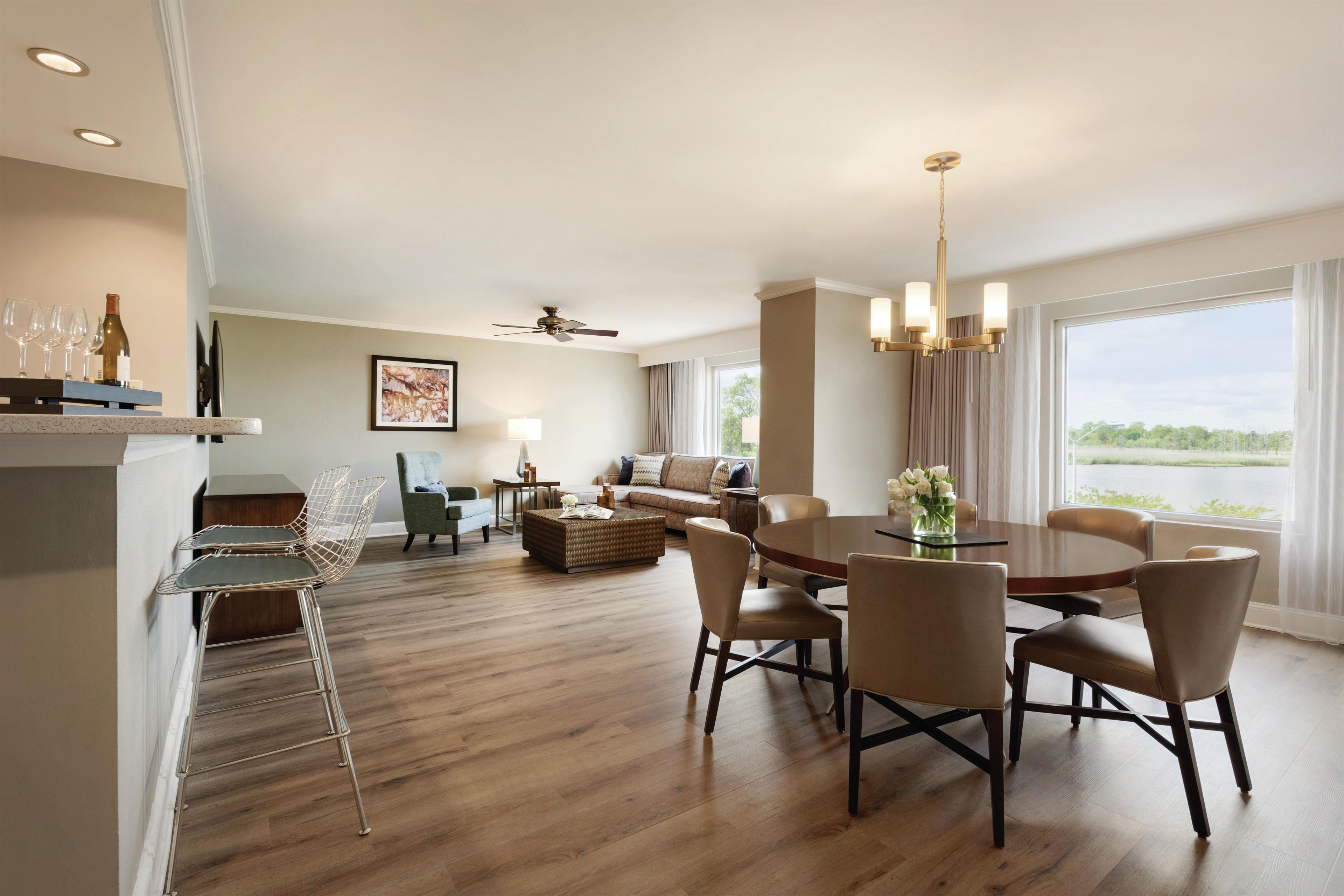Une chambre d’hôtel comprenant un coin repas, un canapé, une table basse et une vue sur l’extérieur.