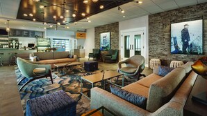 Un área de descanso moderna con sofás, sillones y una barra de café.