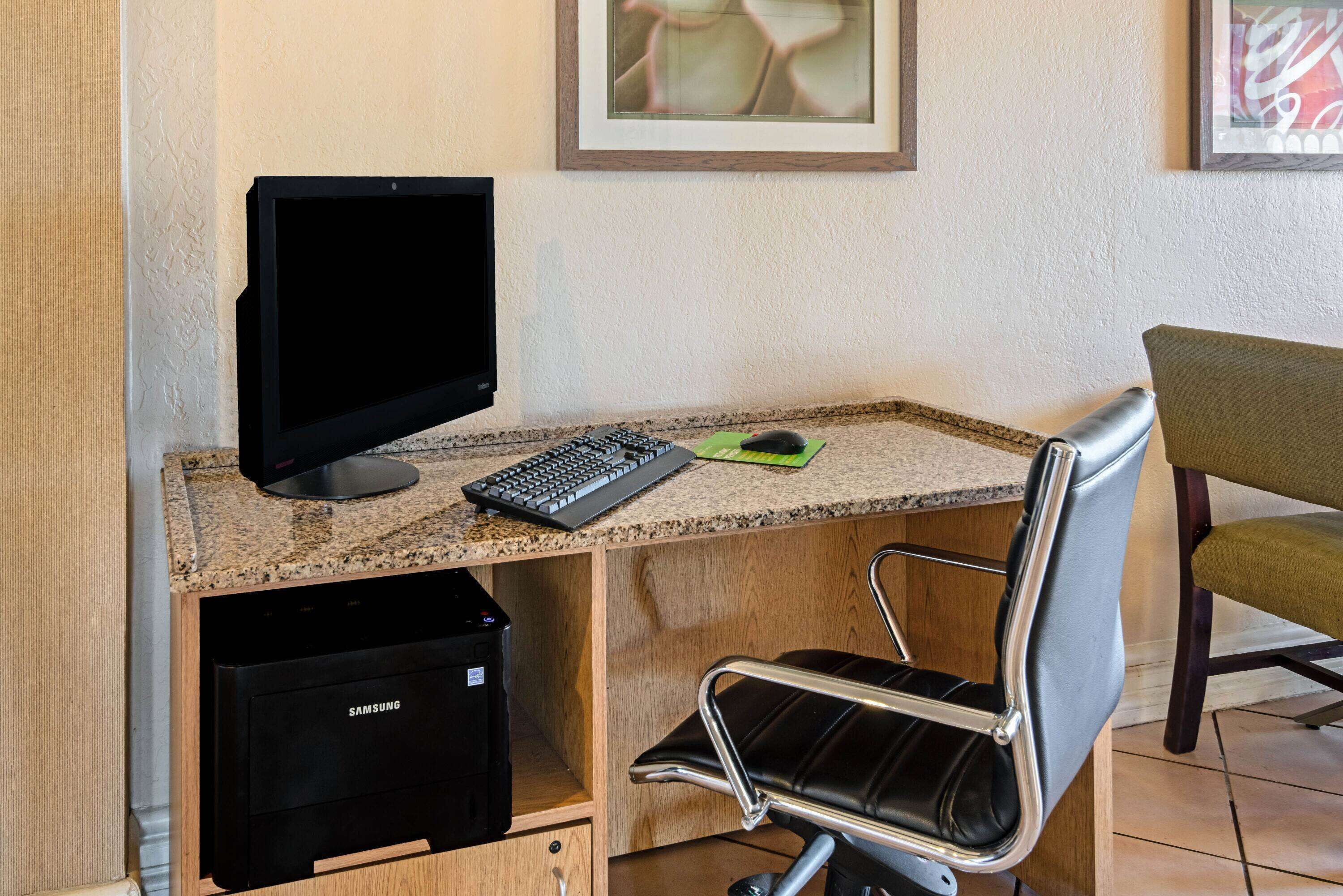Un espacio de trabajo con computadora, teclado, ratón y silla.