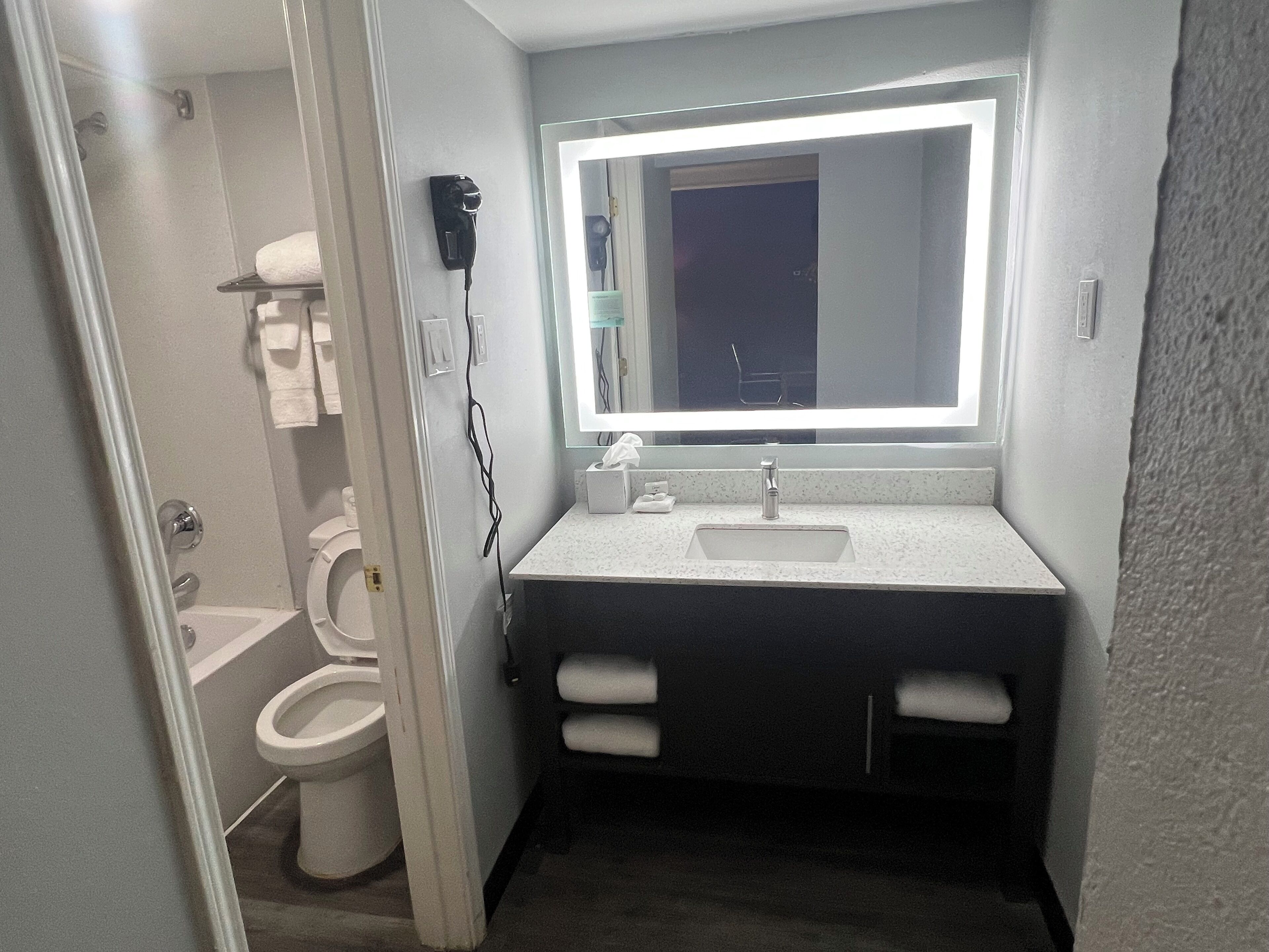 A compact bathroom with a white sink, a mirror, and a toilet.