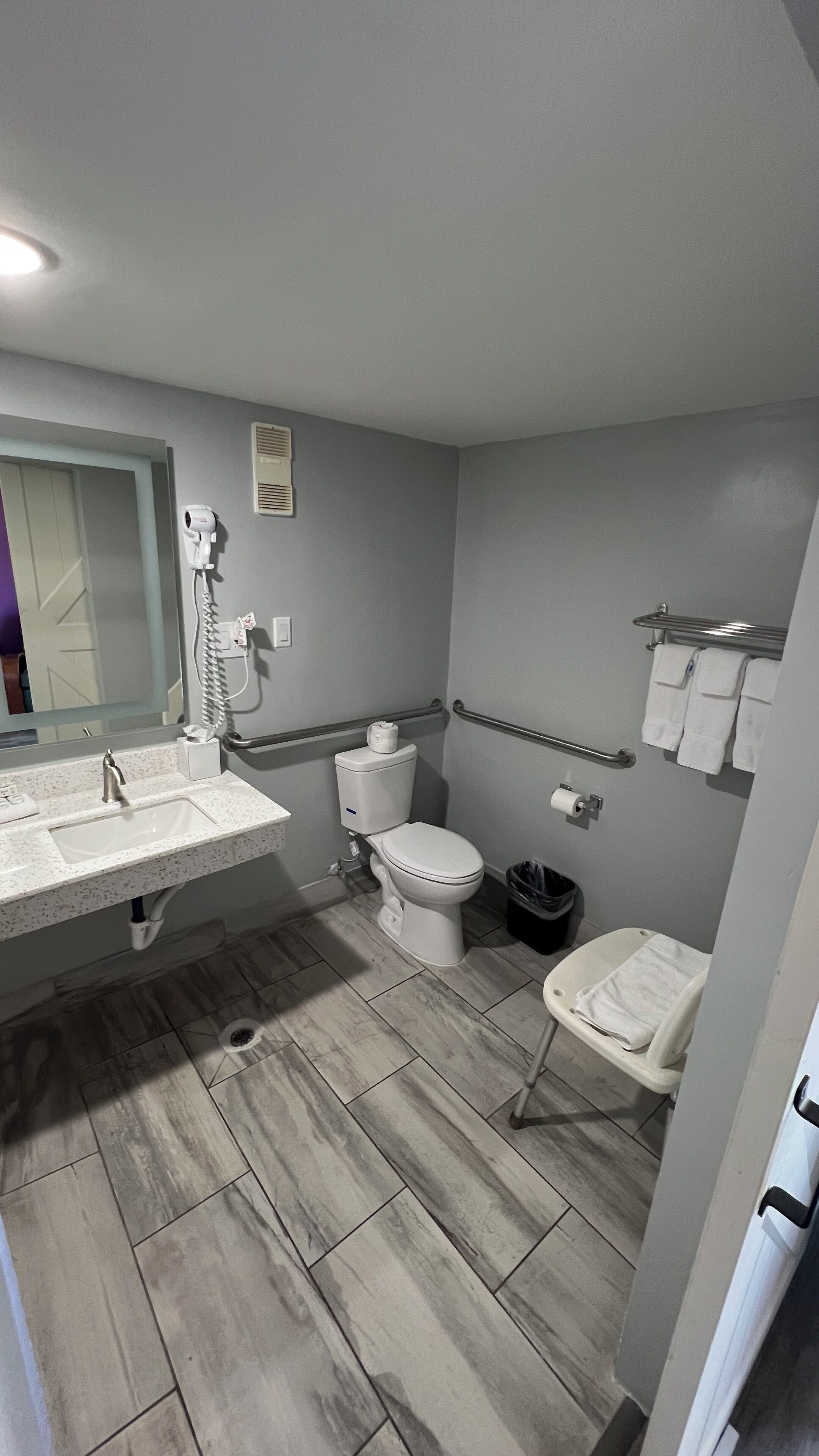 Une salle de bain équipée d’un lavabo, de toilettes et d’un sèche-mains.