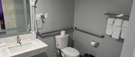 Une salle de bain équipée d’un lavabo, de toilettes et d’un sèche-mains.