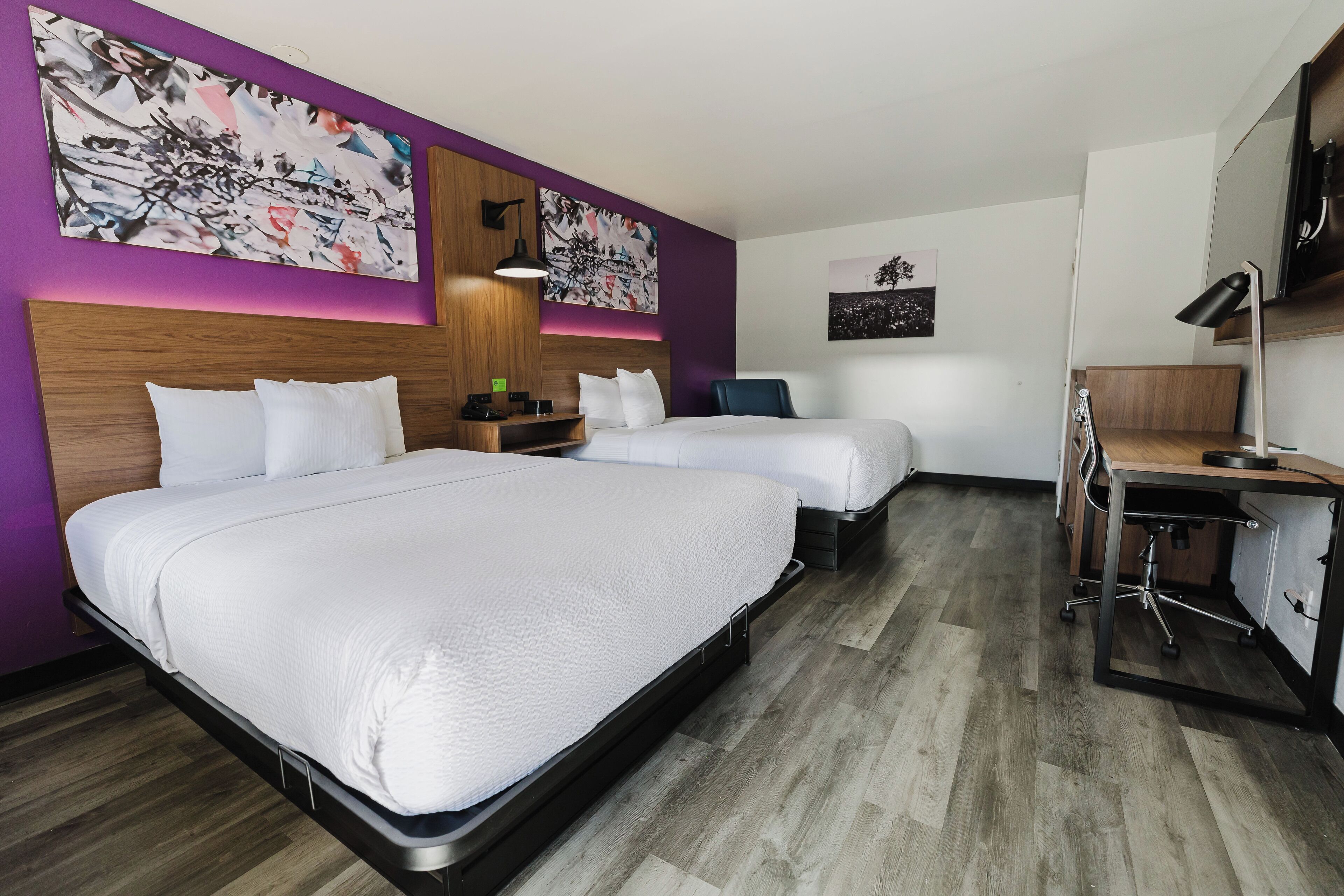 Habitación de hotel con dos camas, un escritorio y una silla.