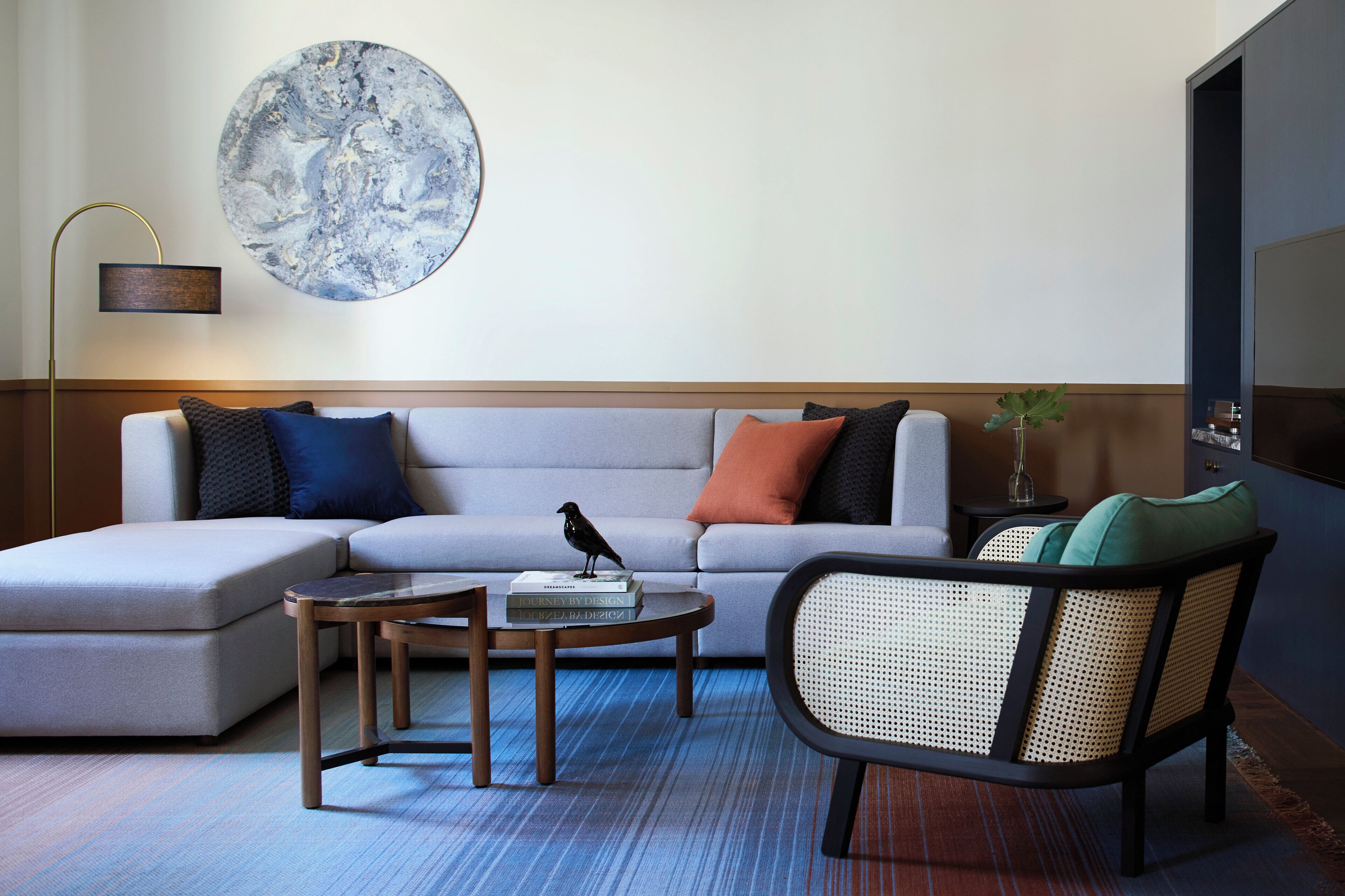 A modern living room with a sofa, a coffee table, a chair, and a decorative bird statue.