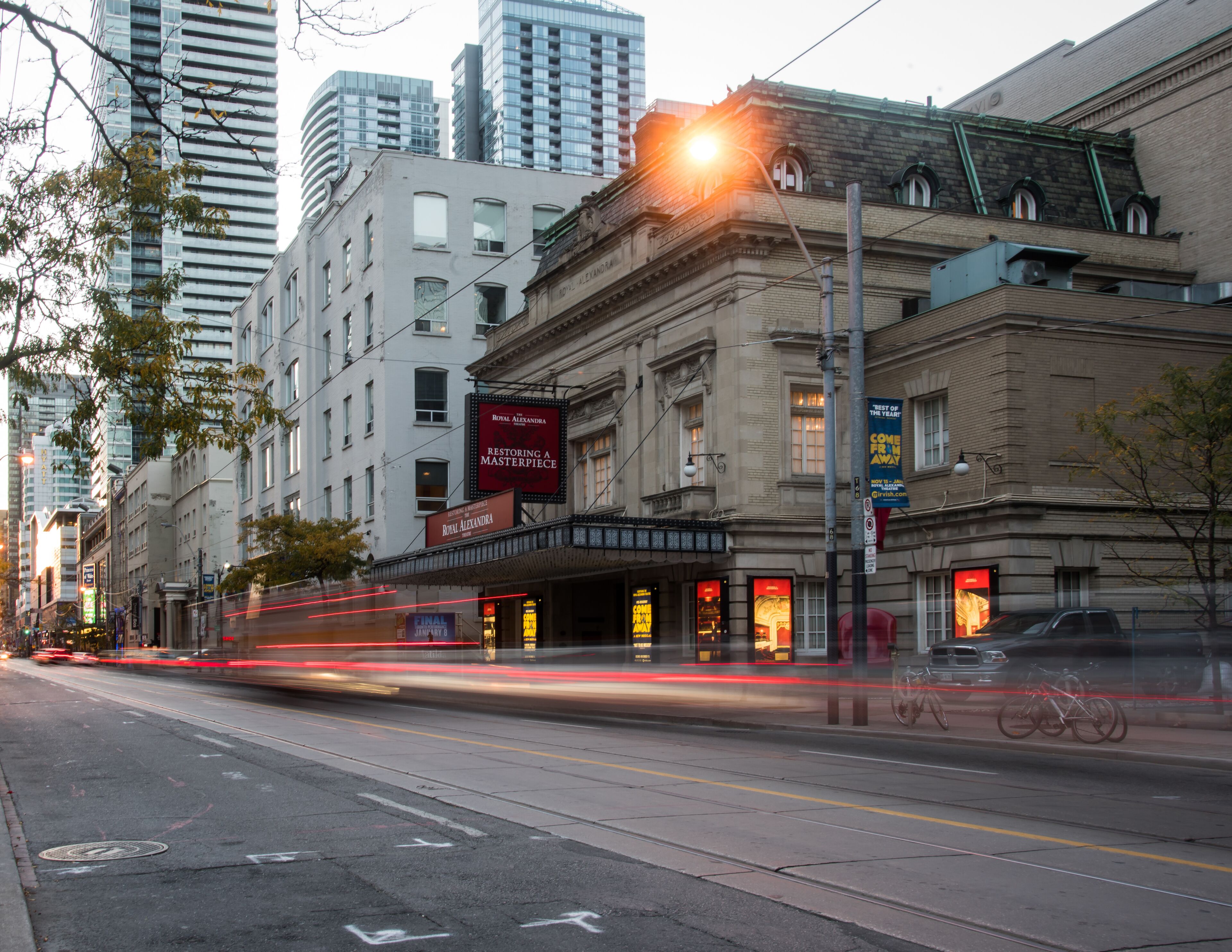 A street view with a building labeled "Royal Alexandra" and a sign for "The Royal Alexandra Restoring a Masterpiece."