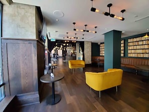 A modern interior with a bar area, seating, and a bookshelf.
