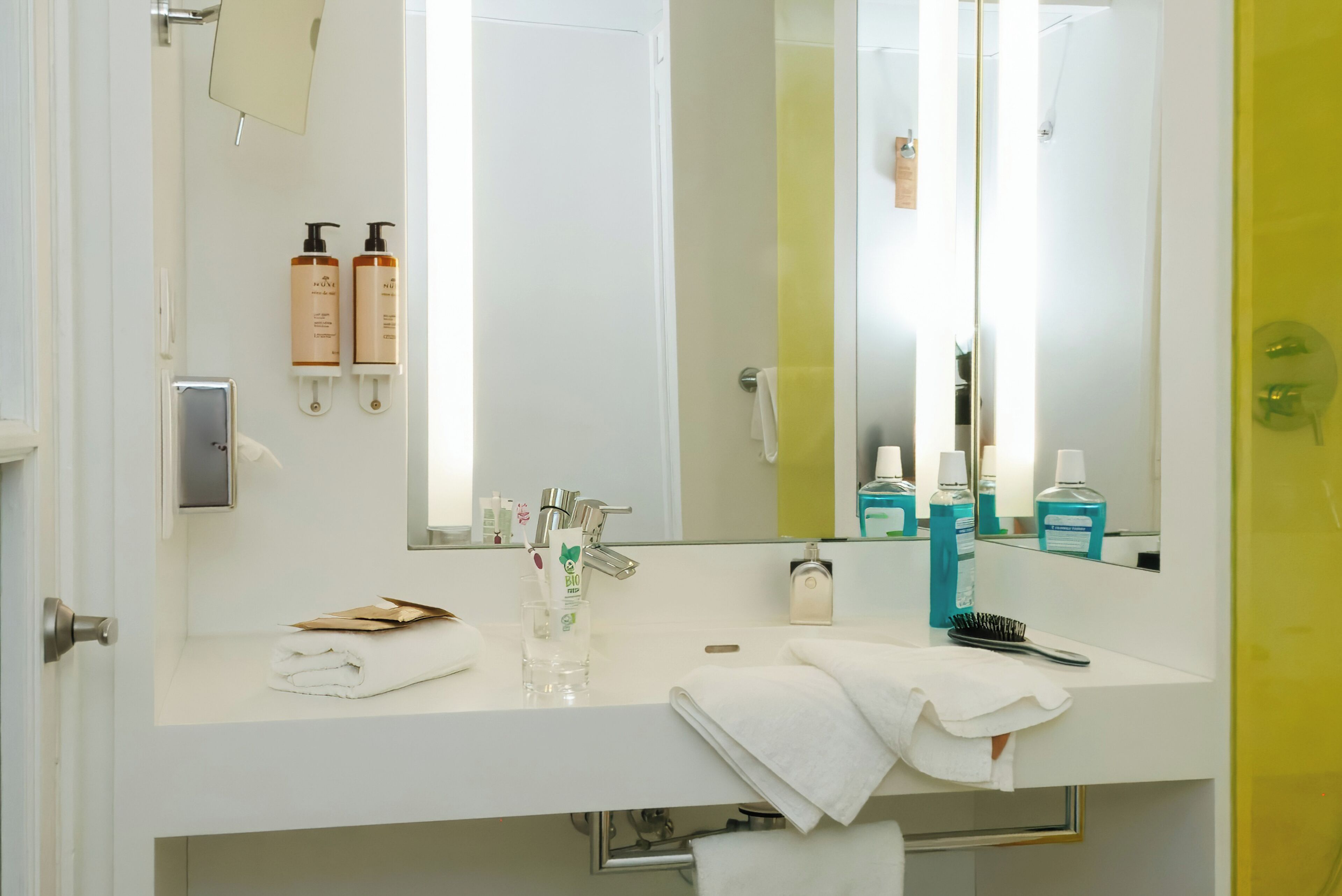A bathroom with a white sink, a mirror, and toiletries.