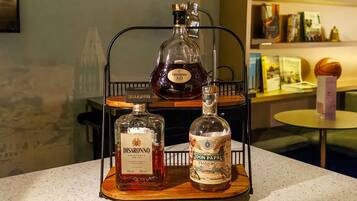 A bar area with three bottles of liquor on a metal rack.