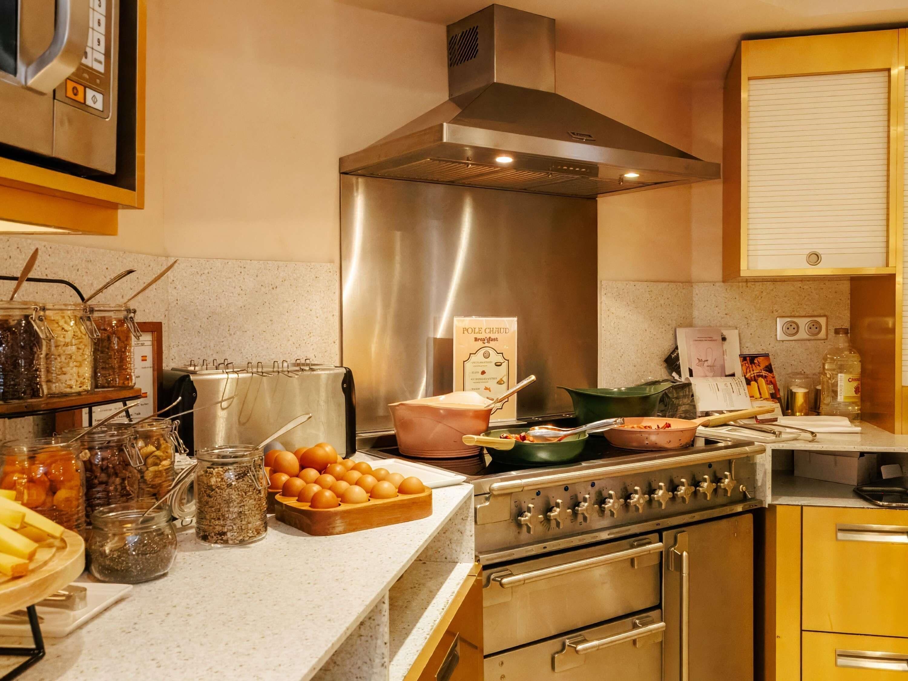 A kitchen with a stainless steel range hood, a toaster, and a variety of food items on the counter.