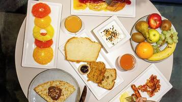 A round table with various food items and plates.