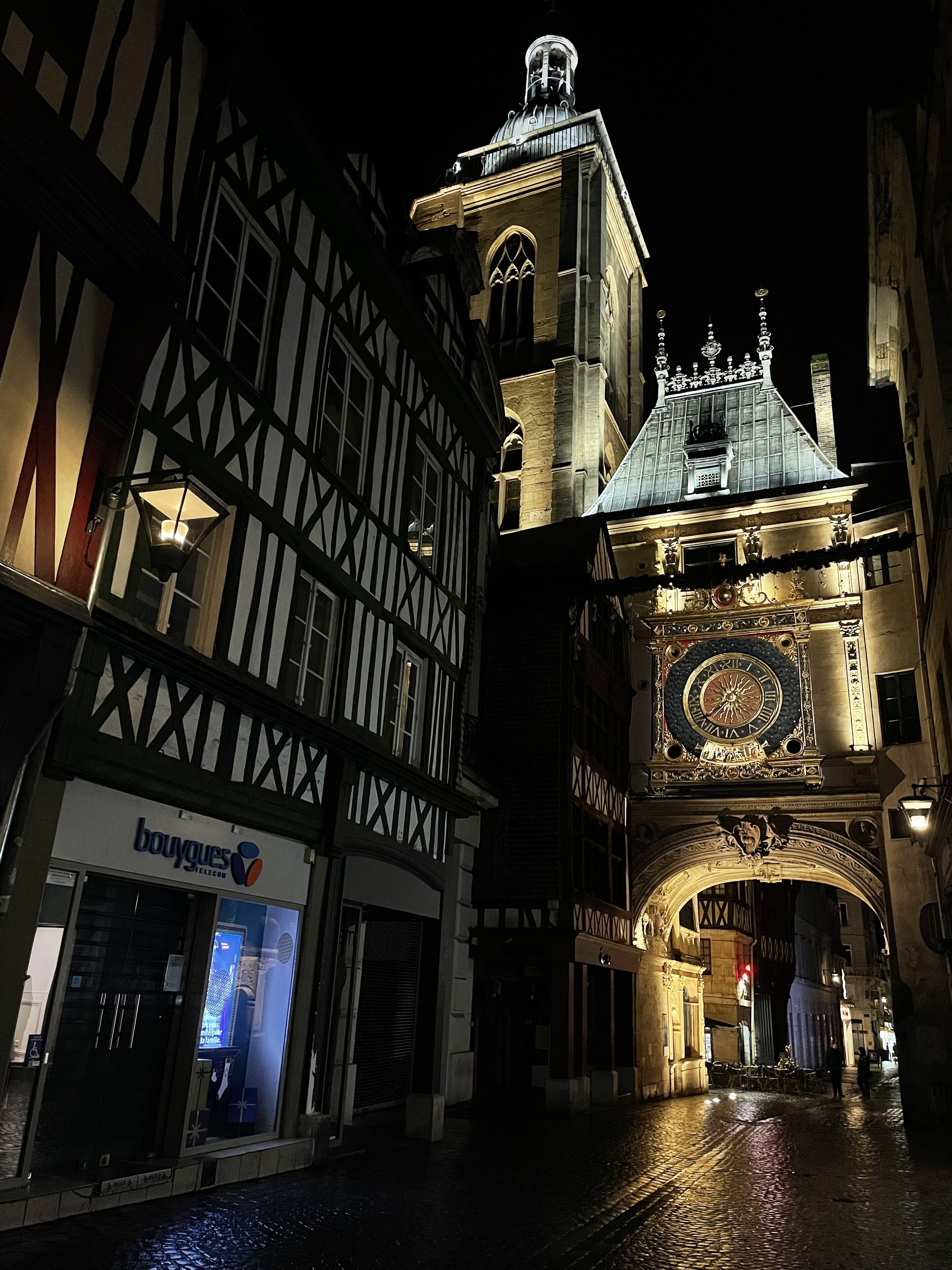 A historic building with a clock tower and a shop named 'bouygues'.