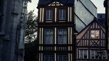 Un bâtiment historique doté d’une flèche imposante et bordé de maisons à colombages.
