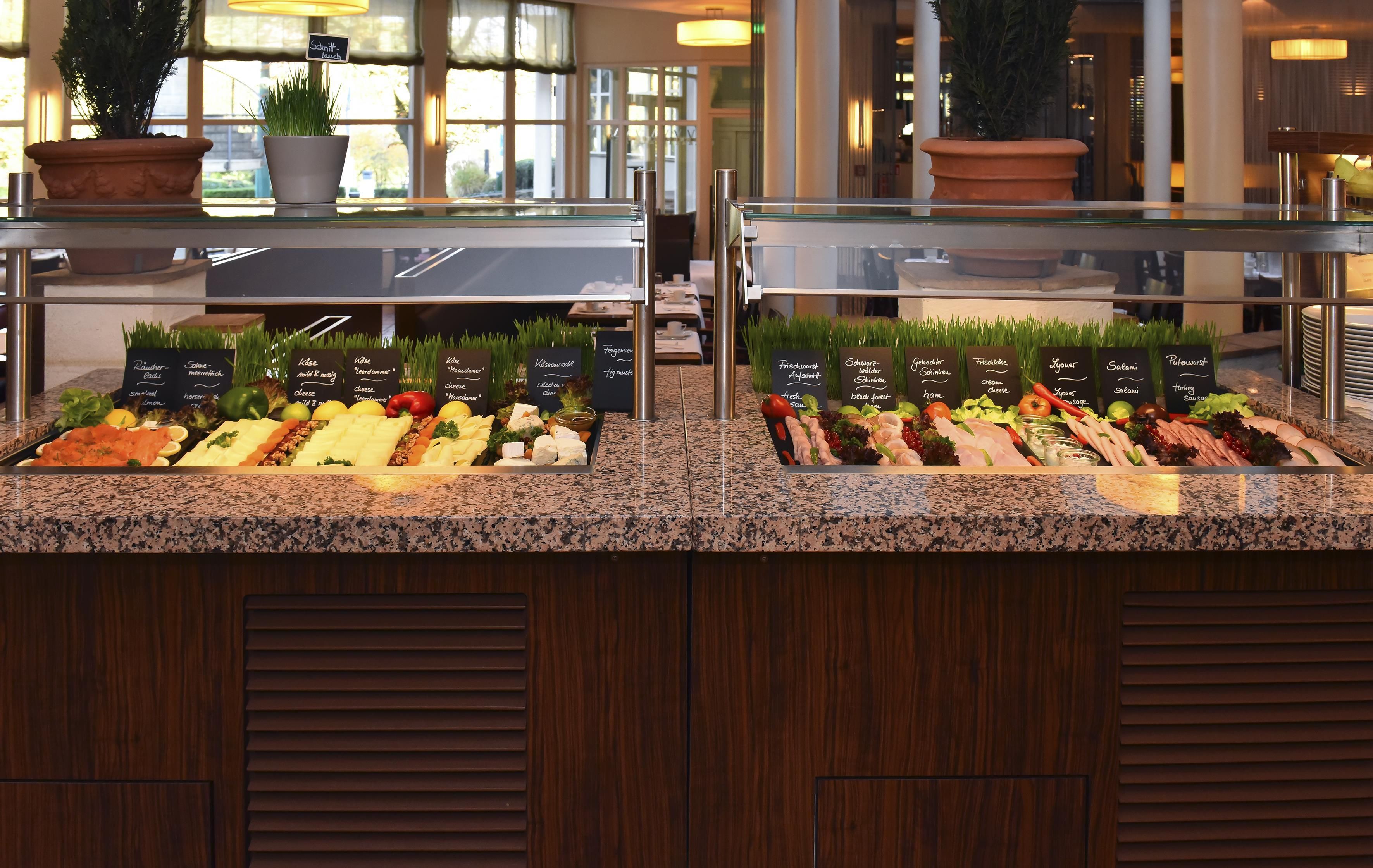 Mostrador de buffet con diversas opciones de comida y etiquetas en un hotel.