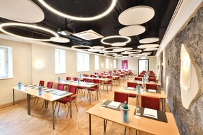 A conference room with multiple tables, chairs, and a modern ceiling design.