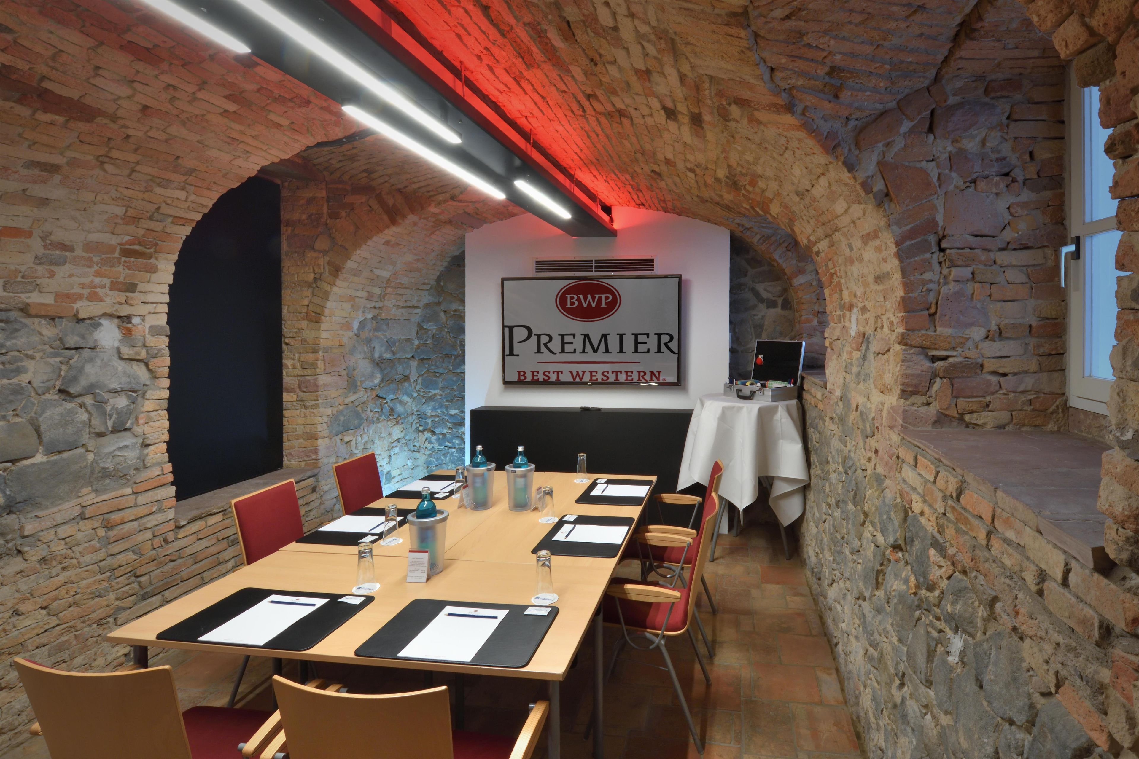 Ein Konferenzraum mit einem langen Tisch, Stühlen und einem Banner mit der Aufschrift 'Premier Best Western'.
